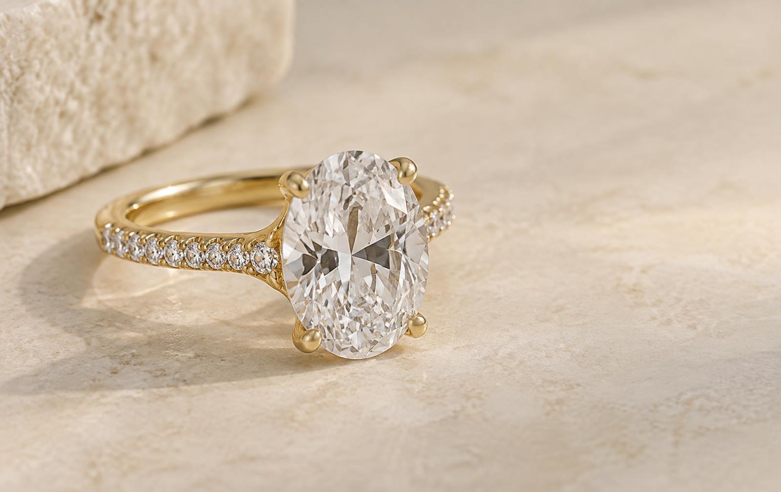 Oval center diamond ring with small shoulder accents used to distinguish center weight from accent total carat weight