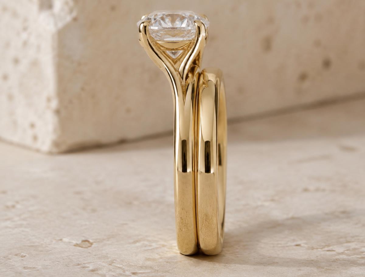 Side profile of an engagement ring whose raised gallery clears a straight wedding band, allowing the two rings to sit flush
